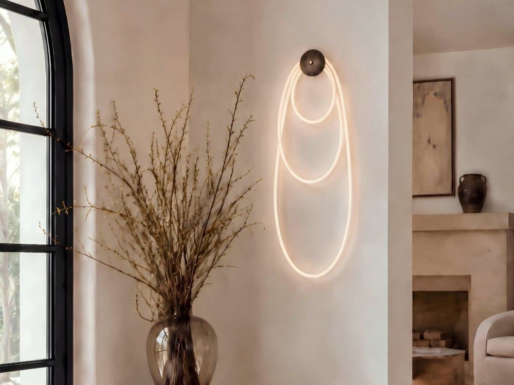 Selene wall sconce in Aged Brass — nested loops of illuminated braided cord from a single canopy
