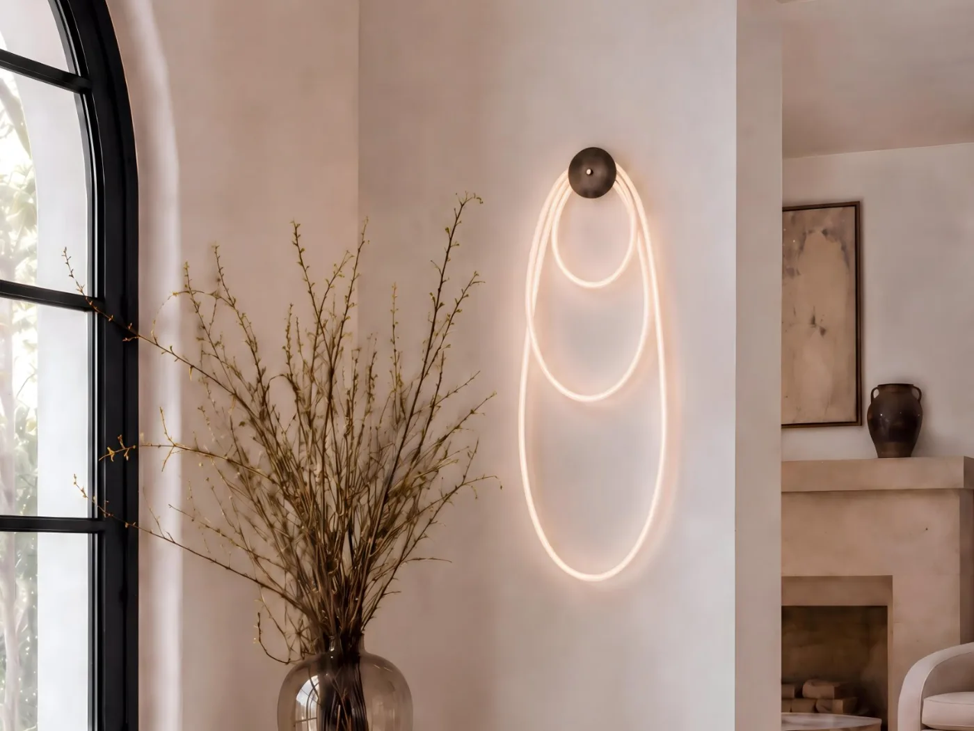 Selene I in blackened brass on a plaster wall beside an arched window, with illuminated cord looped in three nested ovals from a single dome canopy